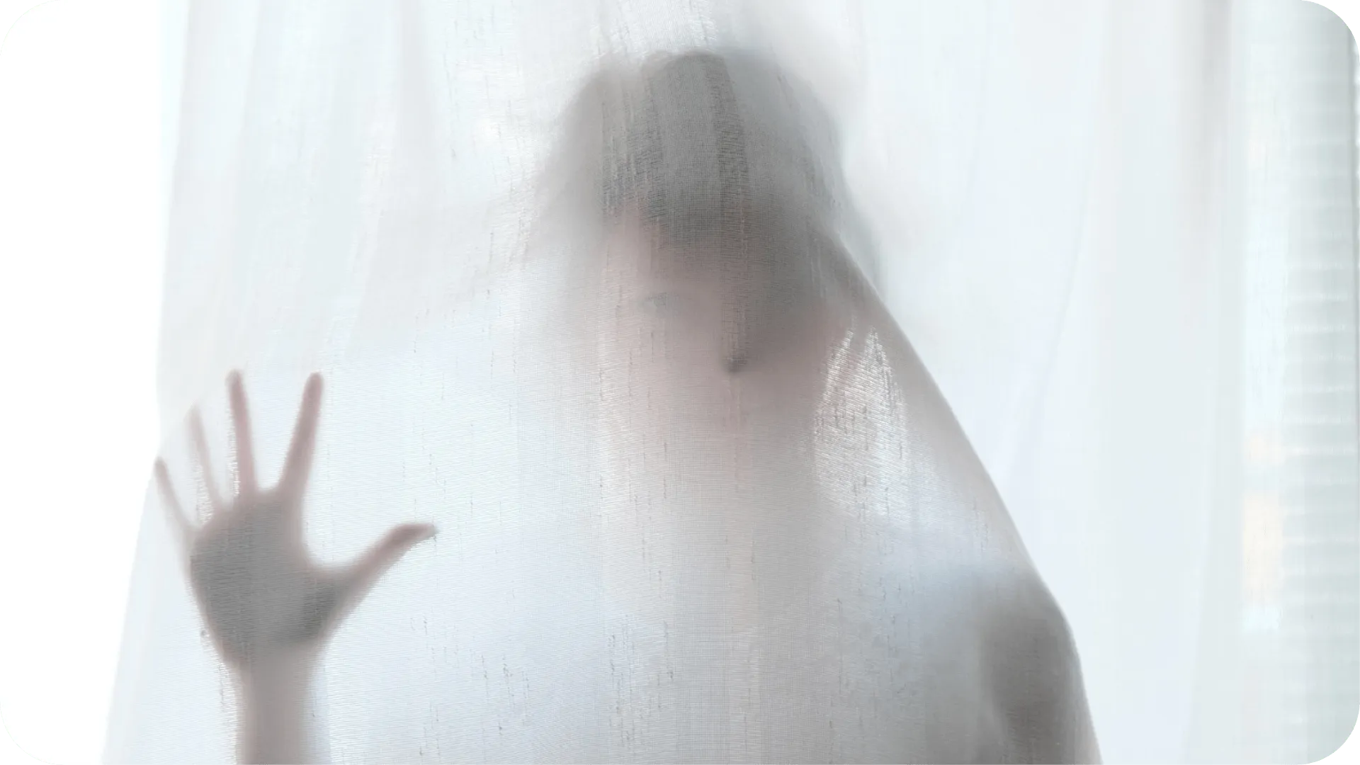 A person stood behind a white cloth, trying to communicate but unable to.